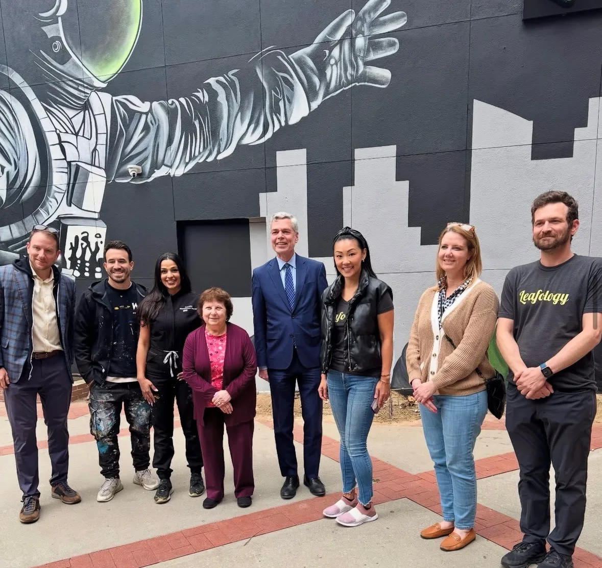Leafology team in front of the astronaut mural at ribbon-cutting day
