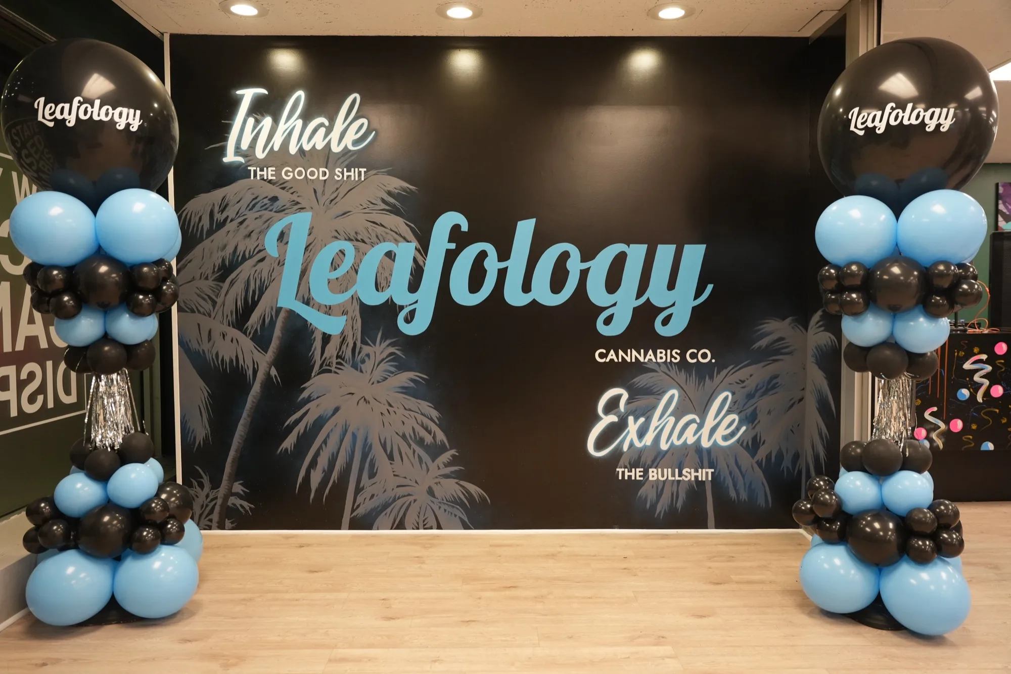 Grand opening at Leafology: Inhale/Exhale wall flanked by black and sky-blue balloon columns