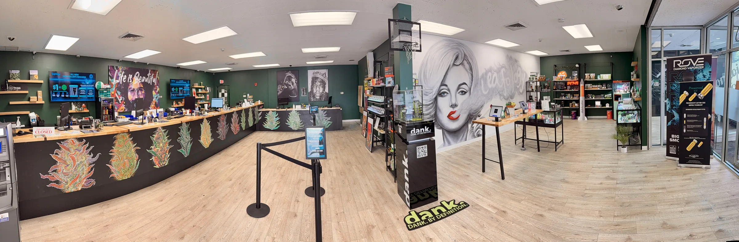 Panoramic view of Leafology sales floor in White Plains: cannabis-leaf graffiti checkout counter, Marilyn Monroe mural, brand displays and light wood floors