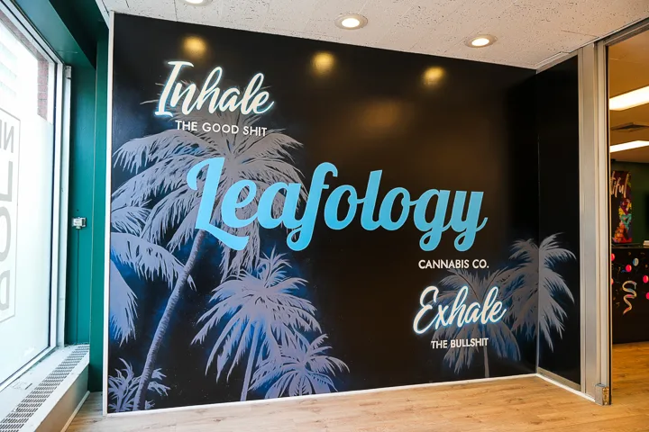 Leafology Inhale/Exhale welcome wall mural: palm trees with cyan script logo and tagline 'Inhale the good shit, exhale the bullshit'