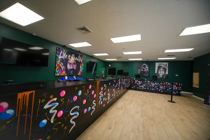Painted Leafology checkout counter with graffiti art, 'Life is Beautiful' portrait and hip-hop icon murals